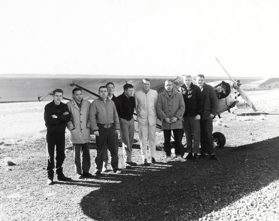 Members of the Vandal Flying Club stand in front of a Piper PA-20 Pacer aircraft posing for a photo.