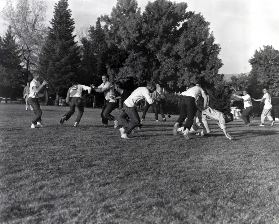 Men playing an intramural game of touch football on the Administration lawn.