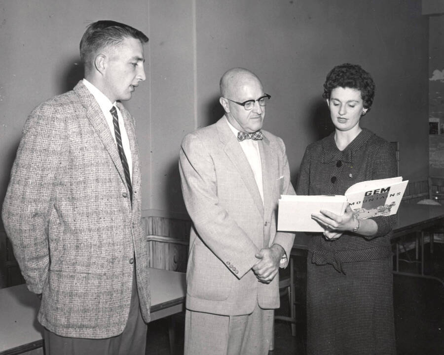 Dick Kerbs, ASUI President, and Kay Conrad present University of Idaho President Donald R. Theophilus with the first copy of 1958 Gem of the Mountains.