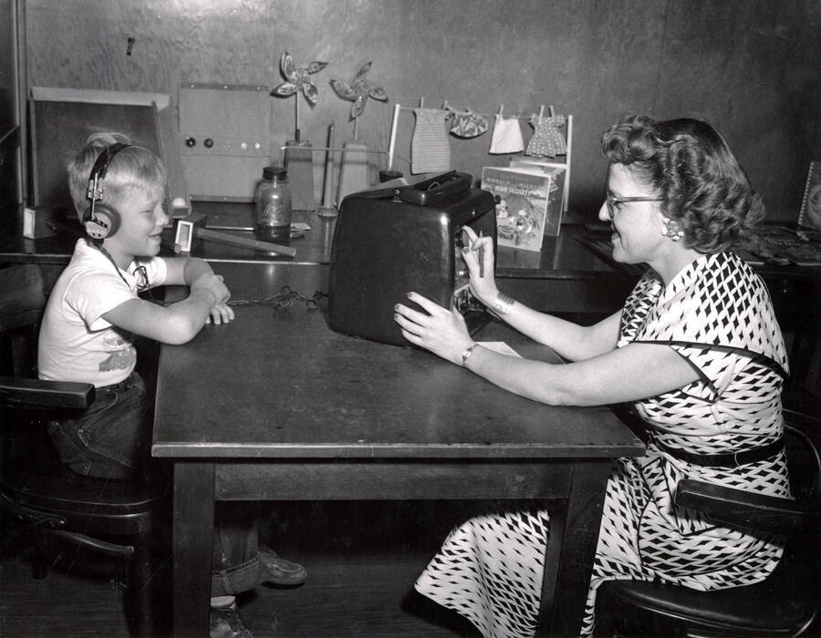 Elsie Geddes, speech specialist, tests a childs hearing in the Summer Child Guidance Clinic.