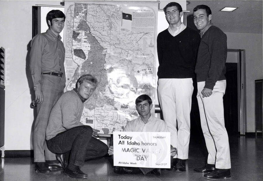 Five men stand together in front of a map of Idaho, with one man holding a sign that reads: 'Today All Idaho honors Magic Valley Twin Falls Day.'