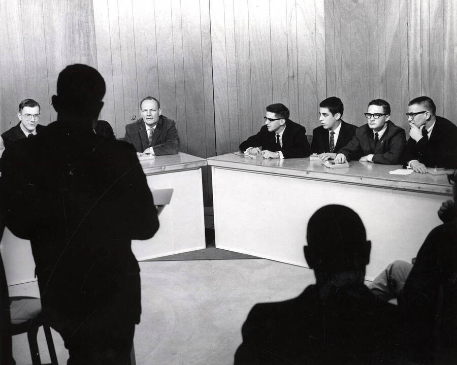 An audience shot of participants of the General Electric College Bowl answering questions from the announcer. Individuals identified from left to right: Richard Porter, George Kellogg, William Silverly, Steve Merlon, Burton Hunter, George Alberts.