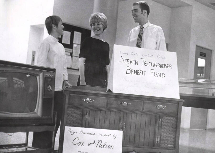 Roger Teichgraeber and his wife Sue stand next to signs about the Teichgraeber Benefit Fund. An unidentified woman stands with the couple.