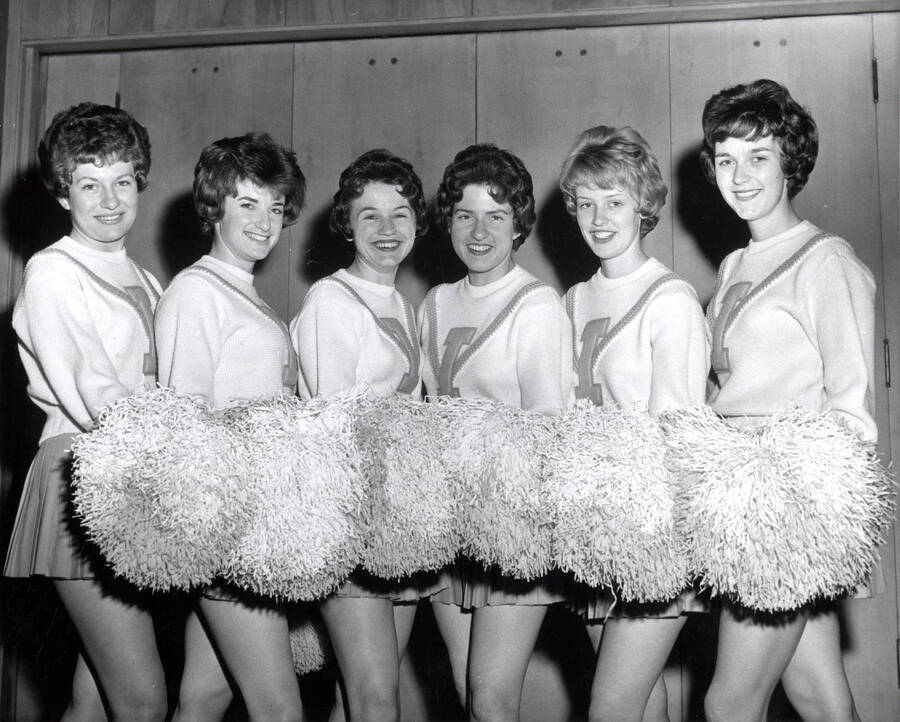 The Pom-Pom girls pose for a group photograph while holding their poms in front of them.
