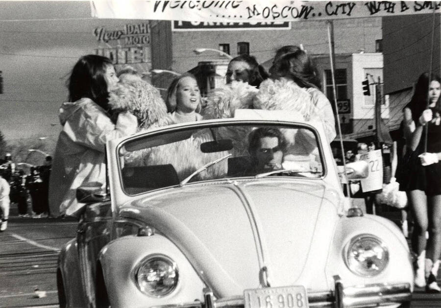 Pom-Pom Girls sit in the back of a Volkswagen Beetle during the Homecoming parade.