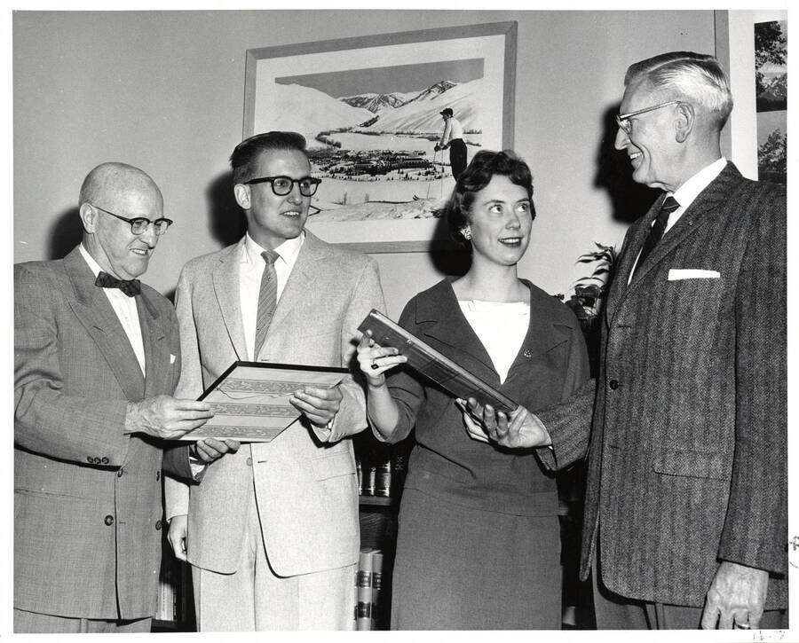 President Donald R. Theophilus (left) looks at leadership plaques presented to Jack Macki and Louise Vandenbark by E.H. Anderson, Moscow branch manager for Standard Oil Co. of California.