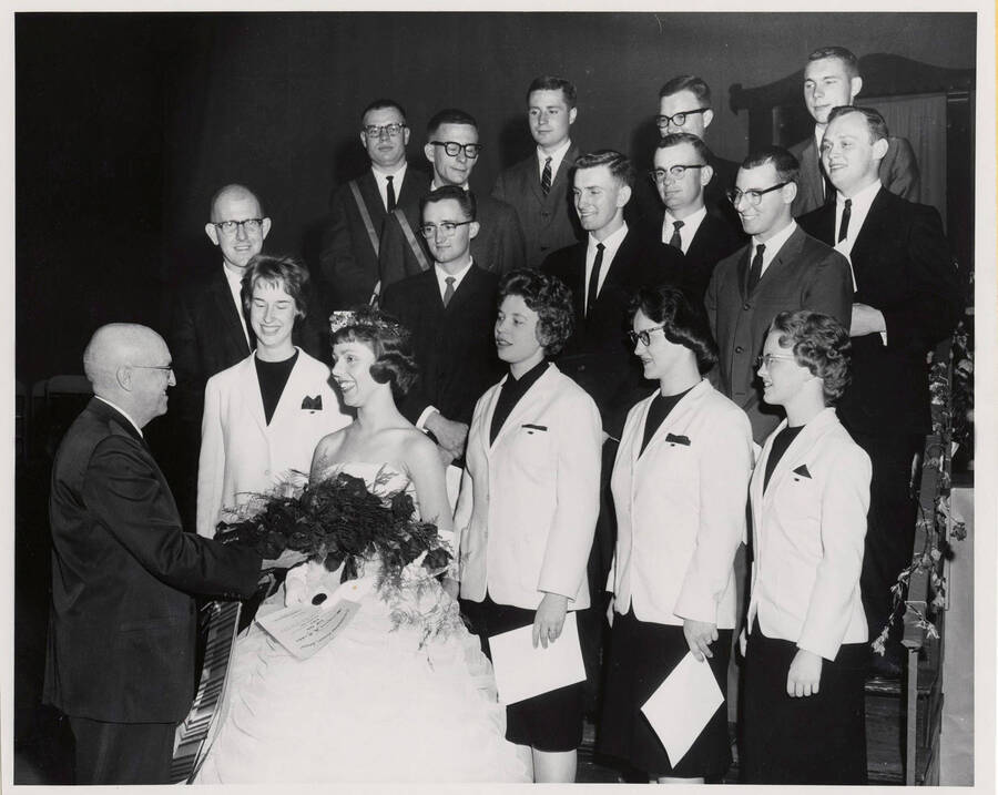 President Donald R. Theophilus congratulates a group of outstanding seniors. Individuals identified as listed. Pictured: Margaret Tatko (May Queen), Karen Stedtfeld, Connie Block Allen, Elizabeth Misner, Beverly Paul, Lloyd Taylor, Everett Baily, Garth Sasser, Bill Pasley, Gordon Chester, Sherman Snow, Bob Moe, J Fitzgerald, B. McCowan, N. Leitner, G. Randall