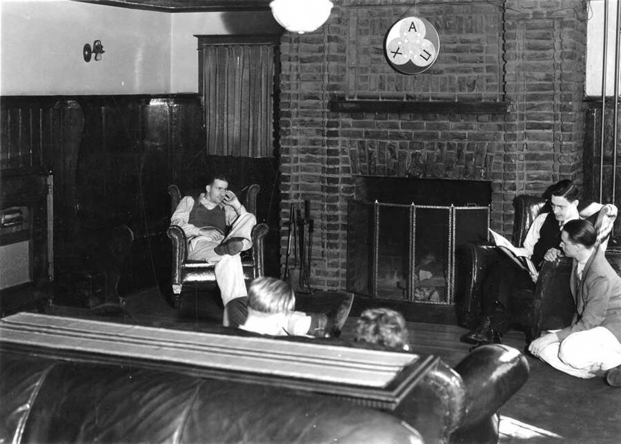 A group of people relax in the Chi Alpha Pi living room at the University of Idaho.