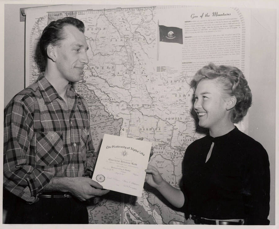 One of the first women in the nation to become a member of Alpha Zeta, national agricultural honorary, University of Idaho student Charlene Roth accepts a certificate from Darrell Weber, chancellor of the Idaho chapter.