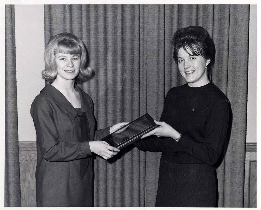 University of Idaho student Diane Beyeler receives a plaque from Patricia Pratt for outstanding freshman student in Home Economics.
