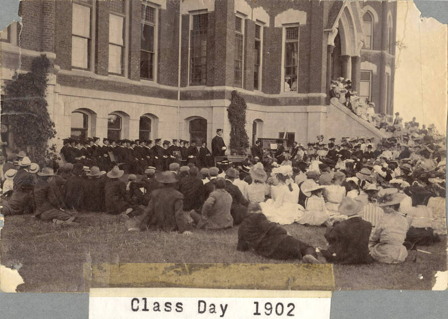 Class of 1902 students and their families sit on the Old Administration lawn listening to a talk from the President.