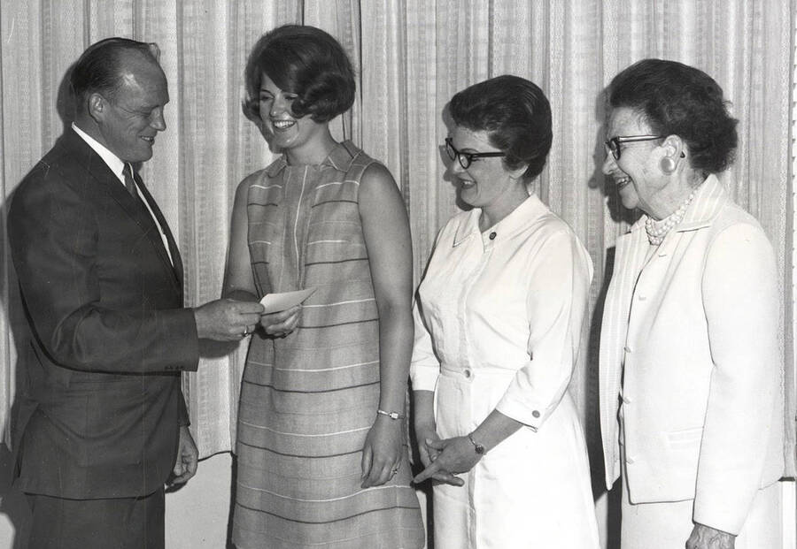 University of Idaho student Susan J. Bamesberger receives a Dubois Chemical $200 dietetic scholarship award from Lee Ostman. Beverly Moorer (2nd from right) and Margaret Ritchie (right) watch the presentation.