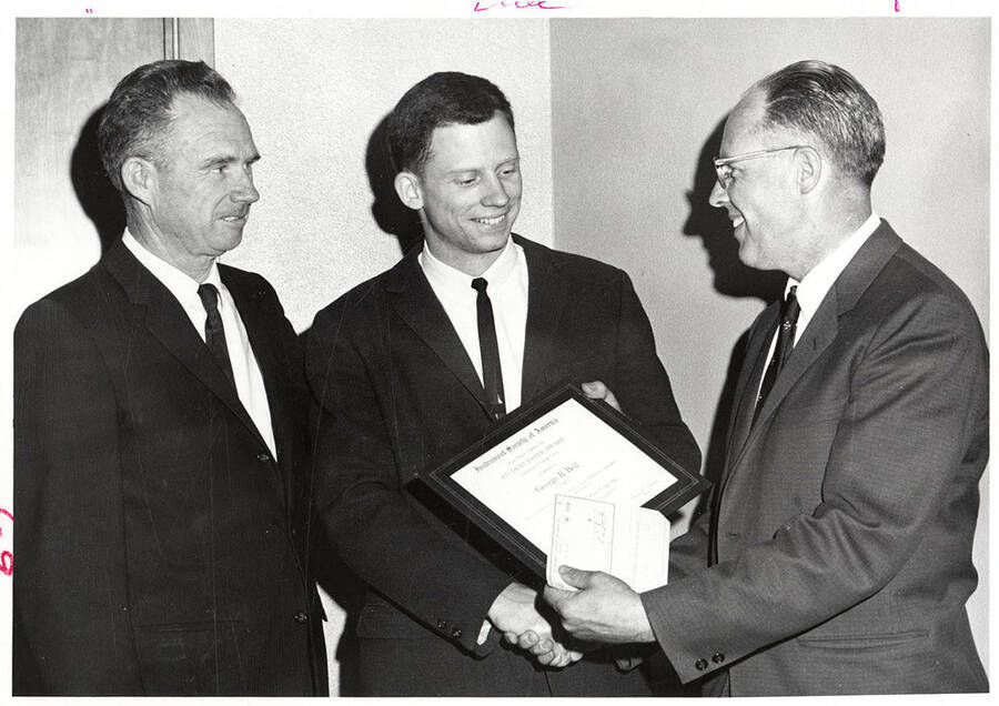 University of Idaho student George B. Bell receives the Student Paper Award from Lowell Jobe as George M. Bell looks on.