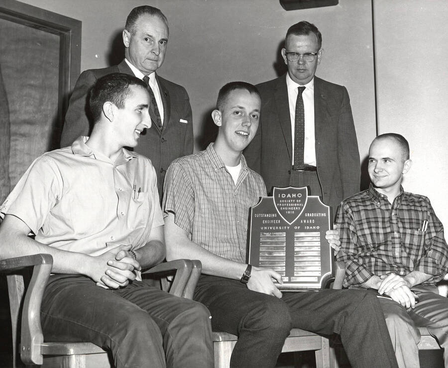 University of Idaho student James Clifford Okeson receives the Outstanding Graduating Engineer Award while sitting next to two other engineering students, Vaughn Estrick (left) and Bill Kindley (right).