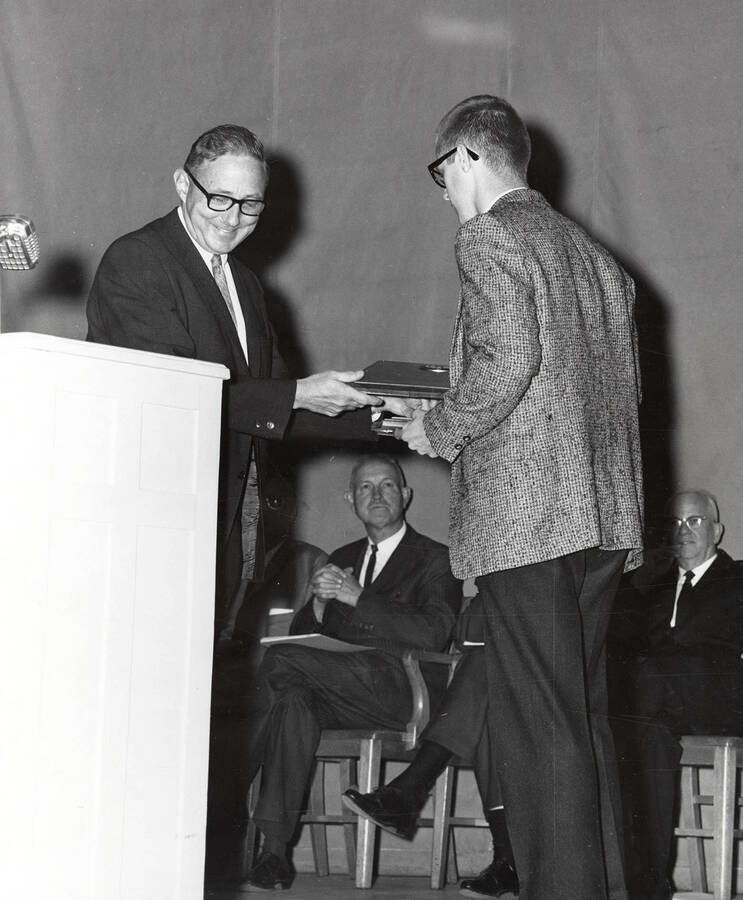 President Ernest W. Hartung congratulates University of Idaho student Gary Ronald Shramek upon receiving the Raymond J. Briggs award.