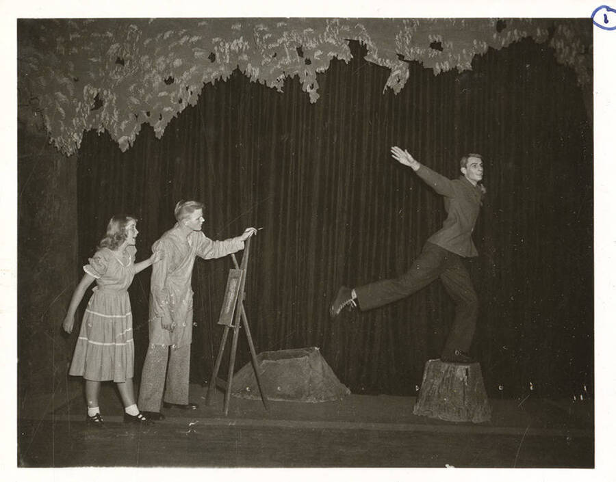 Students from l-r: Colleen Christensen as Margaret, William Davidson as Mr. Dearth, and Guy Terwilleger as Mr. Coade. Terwilleger poses upon a stump during the University of Idaho production of a scene in 'Dear Brutus.'