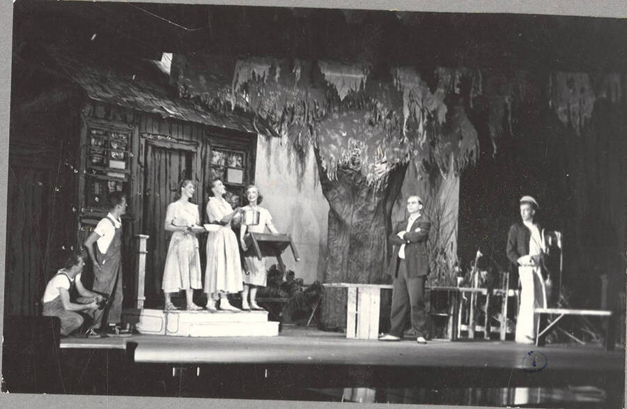 From l-r: Keith Keefer as Elmo, Kenneth Keefer as Fleece, Colleen Christensen as Evvie, Marie Hargis as Mrs. Crochet, Lorraine Cole as Topal, Harry Dalva as Commodore, and Normand Green as Dewey Crochet. Evvie, Mrs. Crochet and Lorraine stand and smile on the doorstep in Idaho drama's production of 'The Great Big Doorstep.'