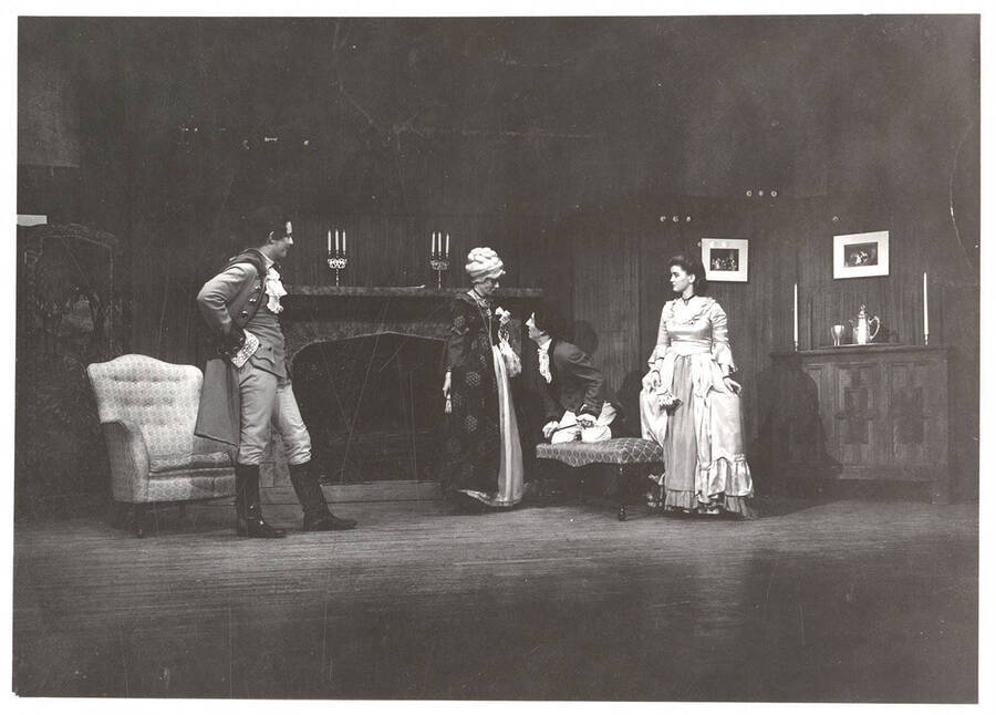 Performers from l-r: Jack Muller as Hastings, Virginia Keeton as Mrs. Hardcastle, Barbara Leach as Miss Nevills and Dennis Savage as Tony Lumpkin. Tony Lumpkin kneels and speaks to Mrs. Hardcastle in Idaho drama's production of 'She Stoops to Conquer.'