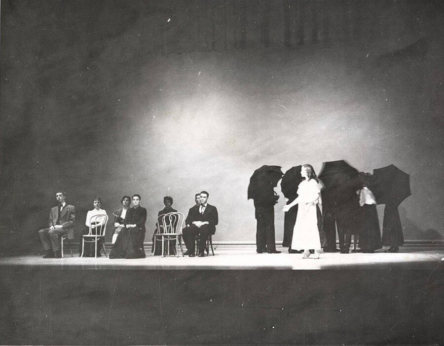 Todd Oleson, Phylis Erickson, Georgette Amos, Joan Fisher, Phyllis Seeley, Tom Baldwin, Willard Wilson, Antoinette Botsford performing a group scene together during a drama production of 'Our Town'.