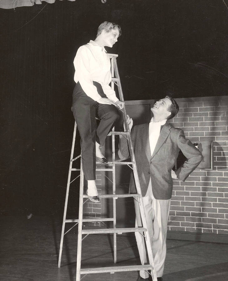 Bert Allen and Mary Jane Milbrath performing on a ladder during a drama production of 'Kiss Me Kate'.