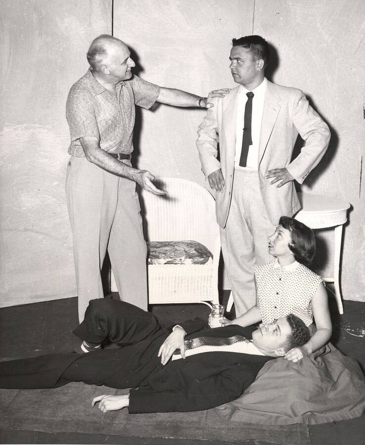 In preparation for a drama production of 'The Moon is Blue,' Director Cecil Matson giving instructions to Claude Hanson as Gary Leaverton and Joan Chavez watch.