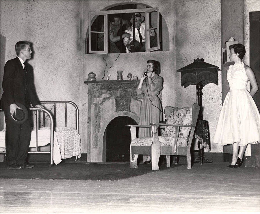 Charles Tovey, Nancy Benfer, Shirley Turner as Eileen and Wayne Crathorne (right in window) performing together on stage during a drama production of 'My Sister Eileen'.