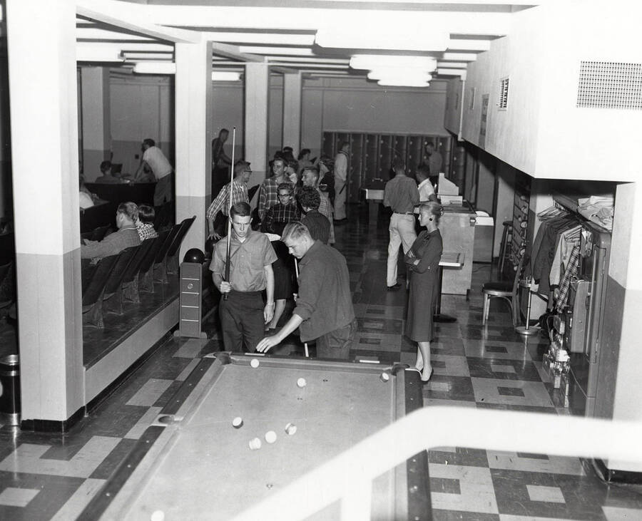 Students play pool and hang around the basement of the Student Union Building during the open house after completion of the third addition.