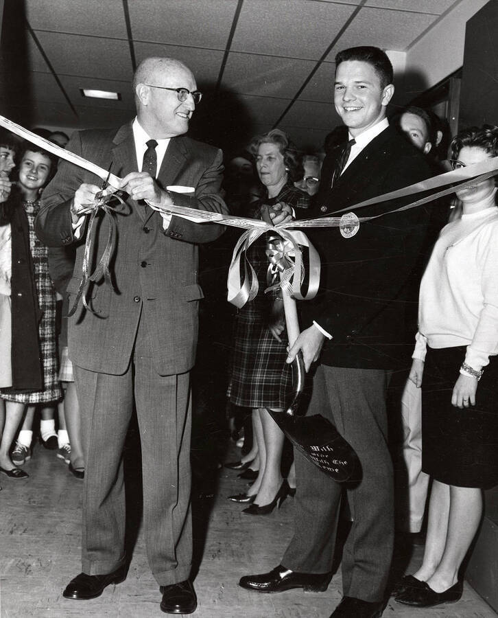 University of Idaho President Donald Theophilus cuts the ribbon at the grand opening of the Dipper, the last section built on the Student Union Building.