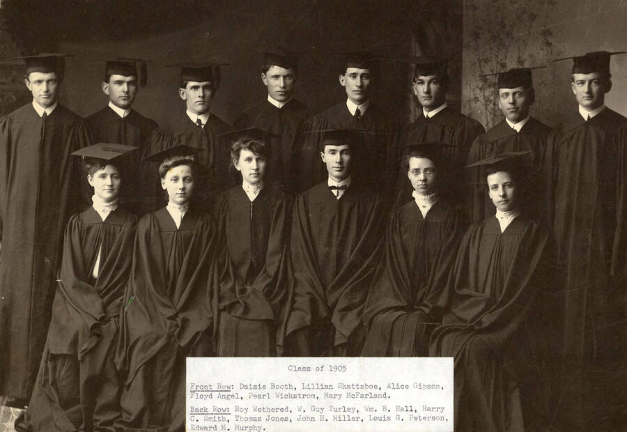 A group photo of the class of 1905 as seniors in their caps and gowns. Front: Daisie Booth, Lillian Skattaboe, Alice Gipson, Floyd Angel, Pearl Wickstrom, Mary McFarland; back: Roy Wethered, W. Guy Turley, William B. Hall, Harry C. Smith, Thomas Jones, John H. Miller, Louis G. Peterson, Edward M. Murphy