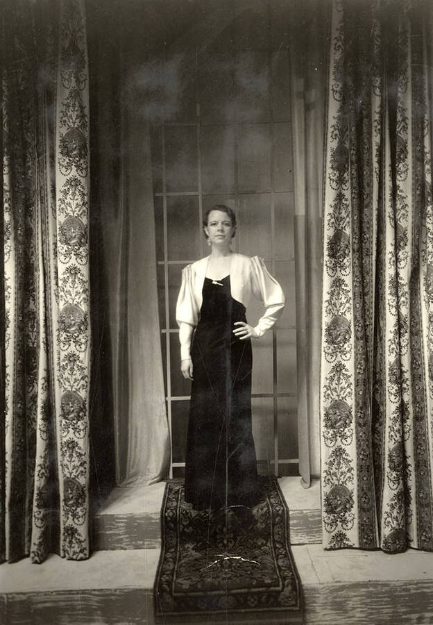 Freda, the mystery woman, standing in front of a window during the drama production of 'Dangerous Corner.' Cast: Robert Herrick as Gordon Whitehouse, Dorothy Pierce as Freda Chatfield, Eldred Stephenson as Robert Chatfield, Alline King as Olwen Peel, Paul Selby as Charles Stanton, Nina Varian as Betty Whitehouse, Ethlyn O'Neal as Maud Mockridge