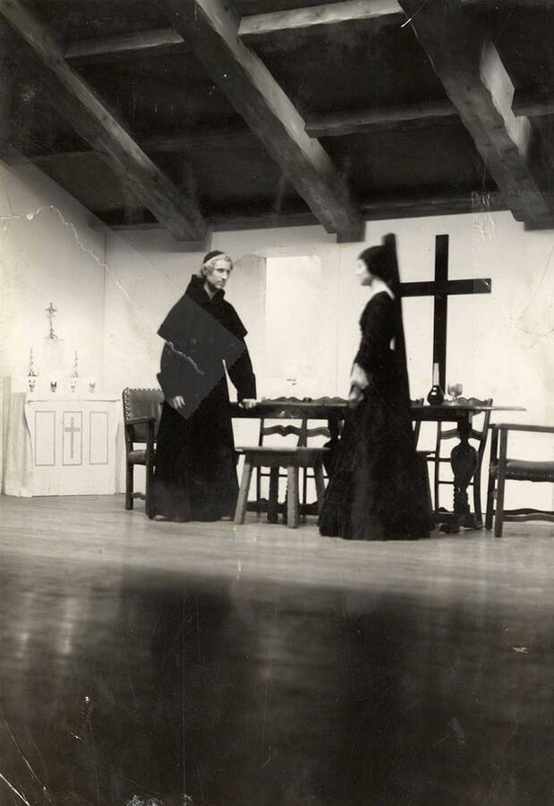 A man and woman stand on stage during the drama production of 'Night Over Taos.' Cast: Eldred Stephenson as Pablo Montoya, Bill Cherrington and Don Tracy as Frederico and Felipe, Malcolm Renfrew as Martinex, Murva James as Diana, Marian Swanson as Dona Josefa and Erma Lewis as Veri