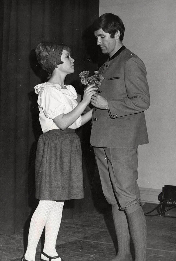 A woman and man hold flowers during the drama production of 'A Tender Moment.'