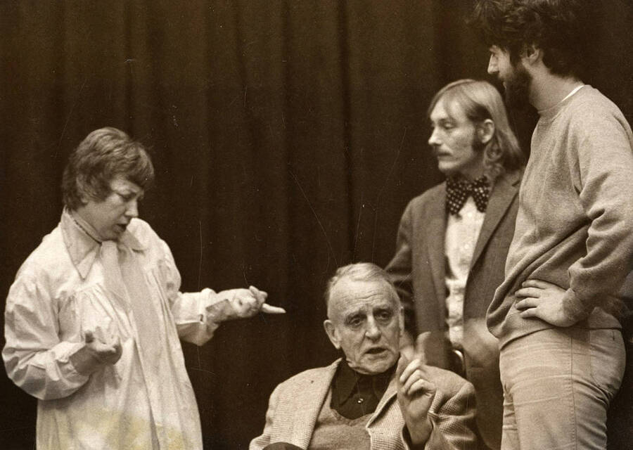 John Fiske, playing Grandpa, refusing to pay his rent to Judy Chavez, playing Penelope. Jim Bateman, playing the son-in-law, and Kenton Bird, playing the iceman Mr. DePinnna, listening in on the conversation during the Moscow Community Theatre production of 'You Can't Take it with You.'