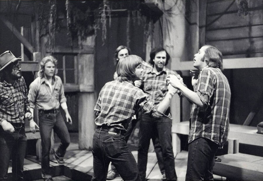 A group of men stand on stage during the drama production of 'Of Mice and Men.'