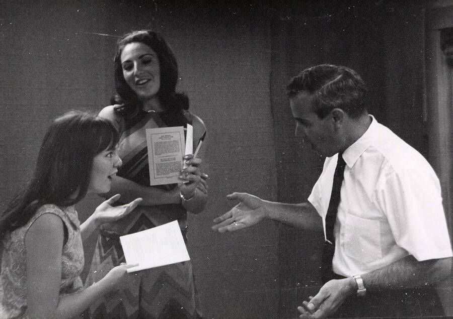 Ed Chavez speaks to two women during a drama production.