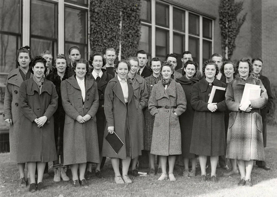A group of second-generation University of Idaho students pose for a picture. Front Row (left to right): Christine Favre (Ogden, Utah), Wilma Johnson (Idaho Falls), Ruth Armstrong, Peggy Nolan (Sandpoint), Helen-Ann Sutton (Weiser), Verla Durnt (Welipe). Second Row (l-r): Kay Hickman (Moscow), Margaret Frasee (Spokane, Washington), Elsie Mae Stokesberry (Hazolton), Virginia Tweedy (Caldwell), Yvonne Brown (Cataldo), Mabel Ayres (Grangeville), Ann Maguire (Anaconda, Montana). Third Row (l-r): Claude Johnson (Idaho Falls), James West (Beverly Hills, California), Harry F. Rogers (Portland, Oregon), John Small (Moscow), Kirk David (Moscow), Wayne Lowery (Walla Walla, Washington), Don Kjosness (Spokane, Washington), James Donart (Weiser). Miss. Brown and Mr. West are third-generation Idaho students; the rest are second-generation students.