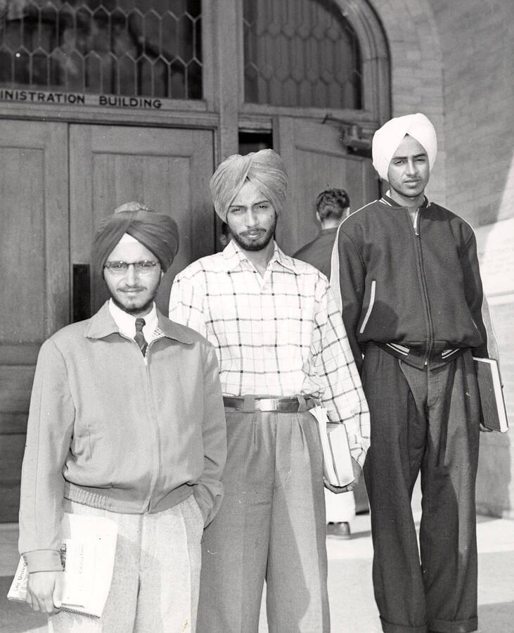 three new students from India, Hajinder Singh Dhillon, Gurcharan Singh Dhillon and Chamkaur Singh Brar, pause between classes on the steps of the Administration Building.