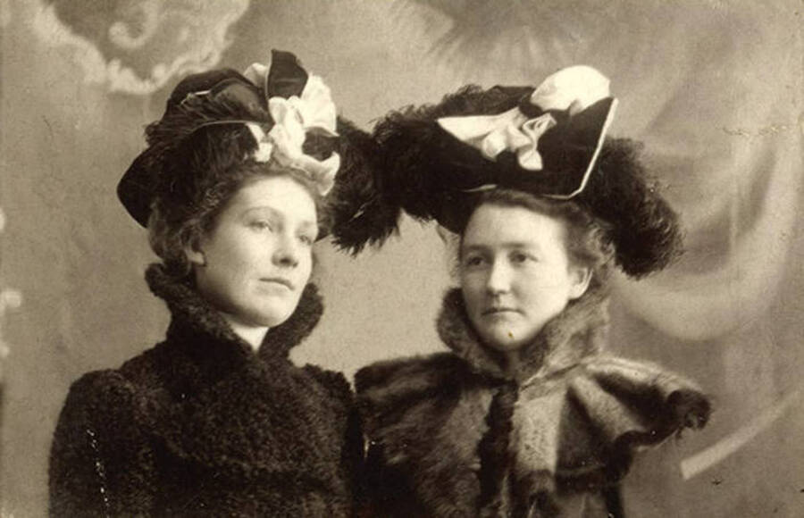 University of Idaho students Mabel Martyn and Marie Cuddy modeling hat styles of 1901 and 1902.
