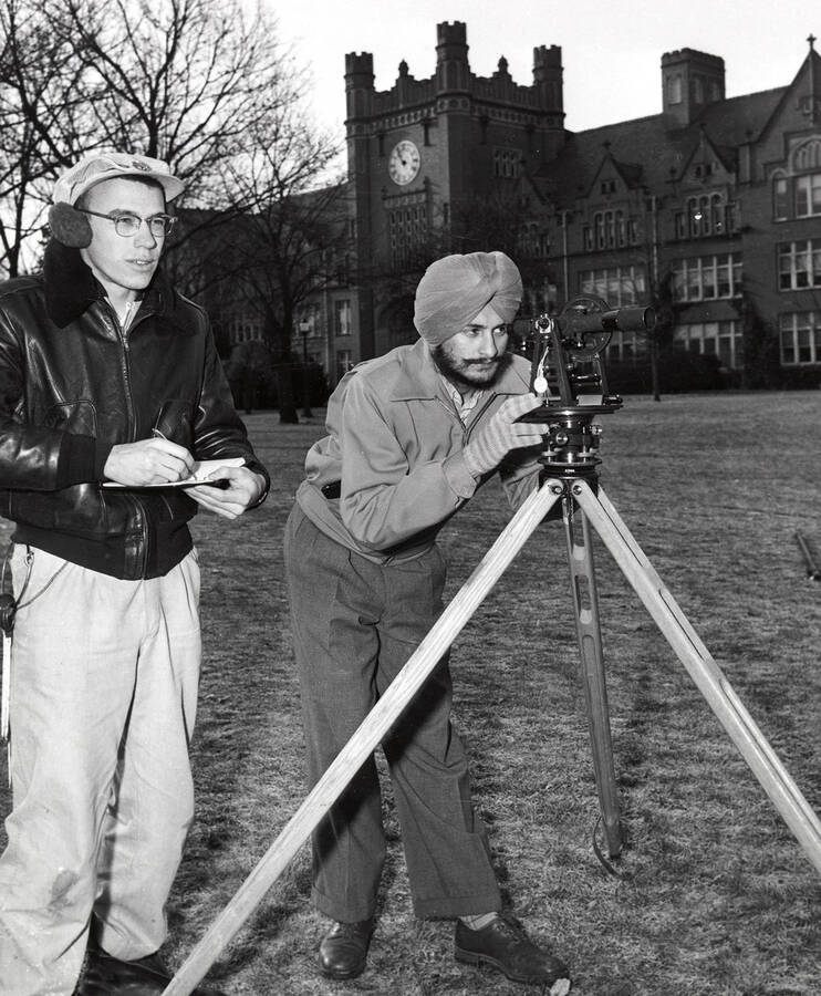 Trilochan Singh Bains, from Punjab, India, stands with surveying equipment in front of the Administration Building.
