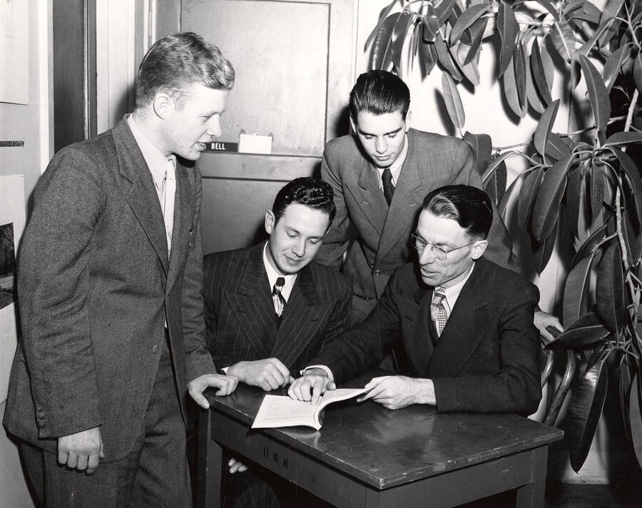 Robert E. Hosack (right) points out something in a book to foreign students Otto Seka, Hubert Bucher and Reinhard Fricke.