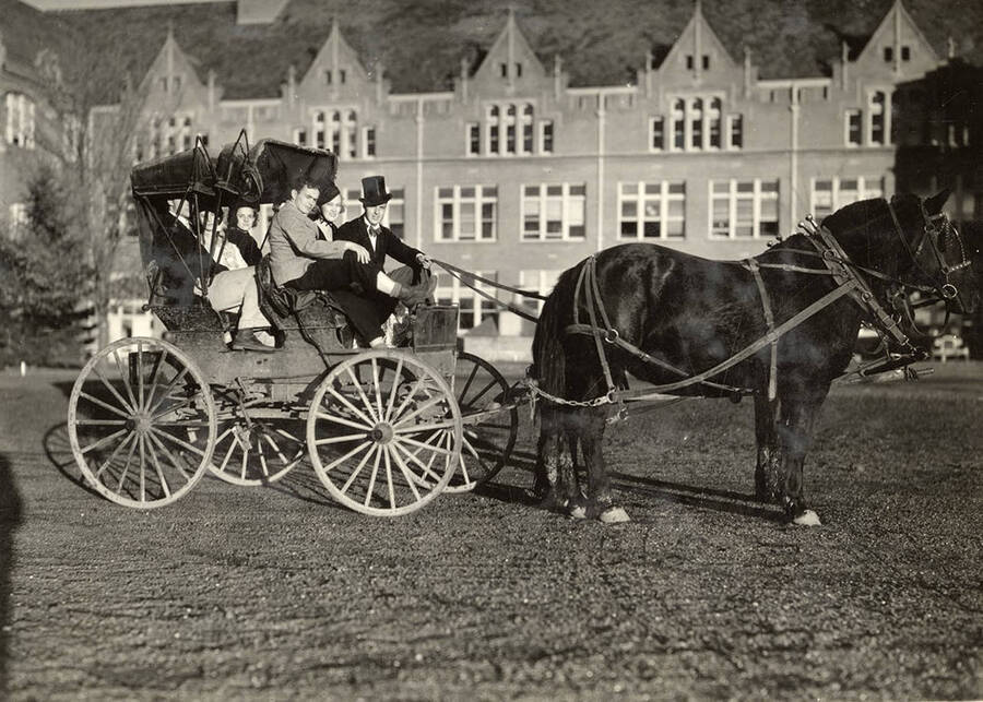Unidentified University of Idaho students sit in a buggy pulled by a team of horses.