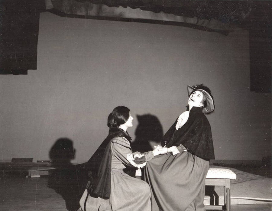 Scene from the University of Idaho drama production of 'Cherry Orchard.' This production was directed by Forrest Sears. One woman can be seen kneeling and holding the hands of another woman.