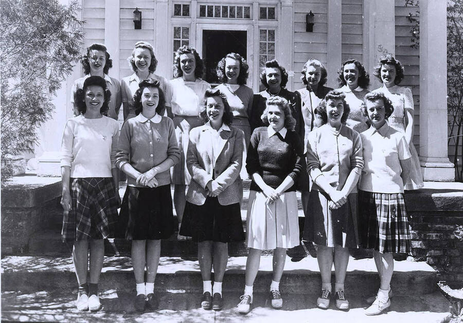 Members of the Kappa Kappa Gamma sorority pose for a group photograph outside of their house.
