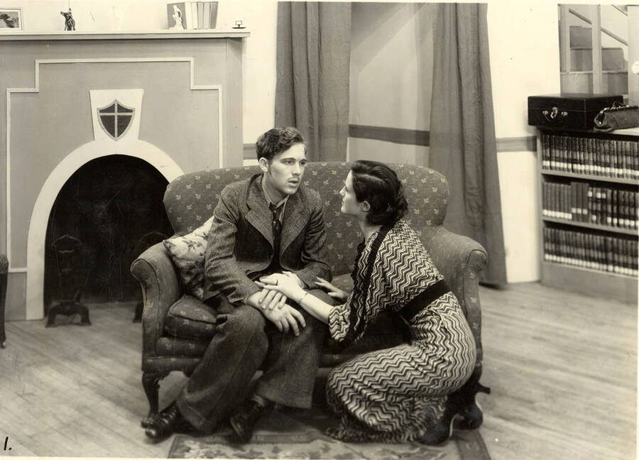 Scene from the University of Idaho drama production of 'Three Cornered Moon.' A woman can be seen kneeling and holding the hands of a man. Cast members include Helen Wilson as Elizabeth Rimplegar, Erma Lewis as Mrs. Eimplegar, Aldrich Bowler as poet, Jean Ricker as Kitty, Burnell Baker as Dr. Stevens, and Catherine Bjornstad as Jenny.