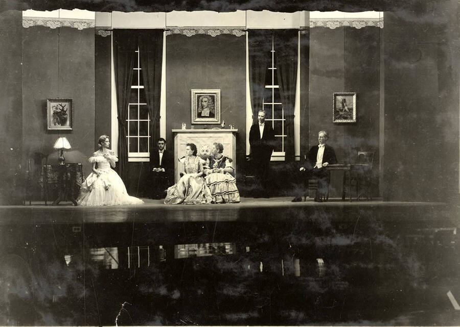 Scene from the University of Idaho drama production of 'Trelawny of the Wells.' In this scene, Miss Trafalgar Gower tells Miss Trelawny sneezing is 'quite out of place.' Members of the cast include Alberta Bergh Utt as Rose Trelawny, Robert Herrick as Tom Wrench, Marion Dresser as Imogen, Clarence Anderson as Colpoys, Jean Ricker as Avonia Bunn and Raphael Gibbs as Sir Gower.
