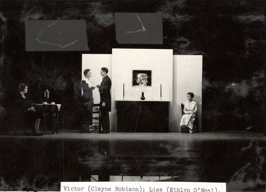 Scene from the University of Idaho drama production of 'The Living Corpse.' In this scene, Victor promises Lisa that he will bring Freya her husband back. Cast members include Fred C. Blanchard as Fedya, Ethlyn O'Neal as Lisa, Clayne Robison as Victor, Alberta Bergh Utt as Masha, Raphael Gibbs as Prince Sergius, Erma Lewis as Anna Pavlovna, Casady Taylor as Petrovitch, Earl Bopp as Artimiev, and Joe Paquet as Petushkov.