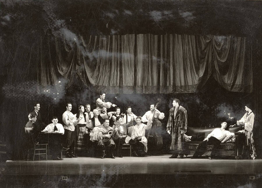 Scene from the University of Idaho drama production of 'The Living Corpse.' This scene is 'when gypsies and a fur coat meet.' Cast members include Fred C. Blanchard as Fedya, Ethlyn O'Neal as Lisa, Clayne Robison as Victor, Alberta Bergh Utt as Masha, Raphael Gibbs as Prince Sergius, Erma Lewis as Anna Pavlovna, Casady Taylor as Petrovitch, Earl Bopp as Artimiev, and Joe Paquet as Petushkov.