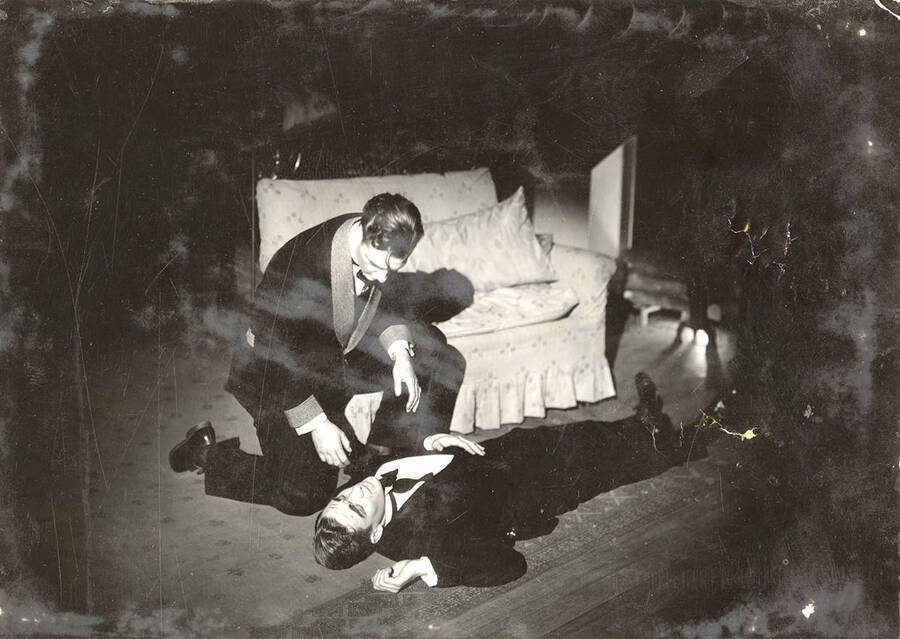 Scene from the University of Idaho drama production of 'Hawk Island.' In this scene, one of the guests is laying on the floor, dead. Members of the cast include Lloyd Ruitel as Paul Cooper, Robert Herrick as Anthony Bryce, Margaret Moulton as Sally Rogers and Alberta Bergh Utt as Madeline Austin.