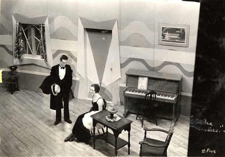 Scene from the University of Idaho drama production of 'To The Ladies.' In this scene, Leonard Beebe and his wife, Elsie, can be seen talking with each other. Members of the cast include John Thomas as Leonard Beebe, Catherine Brandt as Elsie Beebe, Elinor Jacobs as Mrs. Kincaid, Harry Robb as John Kincaid, Howard Altnow, John Milner, Casady Taylor, Rollin Hunter, Franklyn Bovey, Winfred Janssen, Walter Pratt, and Edwin Ostroot.