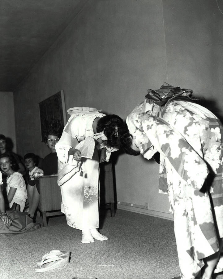 Judy Kempton and Carol Evans bow to one another while dressed in traditional Japanese kimonos as part of the entertainment for rush week guests.